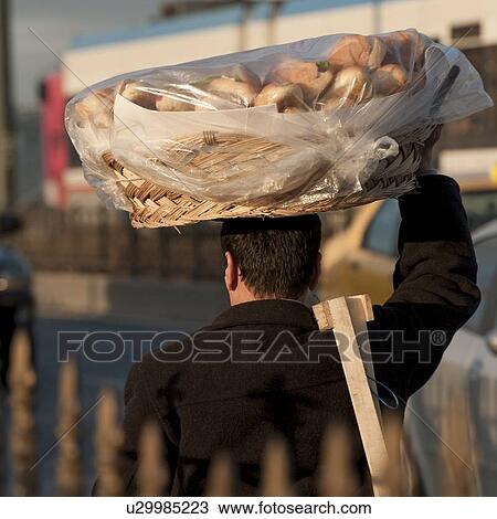 Stock Image - Rear view of a man selling baked breads, Bosphorus, Istanbul, Turkey. Fotosearch