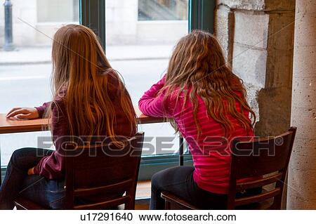 Rear view of two girls sitting in a restaurant, Montreal, Quebec, Canada View Large Photo Image Stock Image - Rear view of two girls sitting in a restaurant, Montreal, Quebec, Canada. Fotosearch