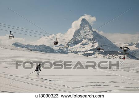 Stock Image - Skier in action with ski lifts in the background, Mt Matterhorn, Zermatt, Valais Canton, Switzerland. Fotosearch
