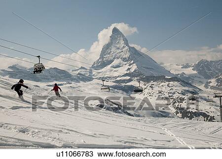 Skiers in action with ski lifts in the background, Mt Matterhorn, Zermatt, Valais Canton, Switzerland View Large Photo Image Stock Image - Skiers in action with ski lifts in the background, Mt Matterhorn, Zermatt, Valais Canton, Switzerland. Fotosearch