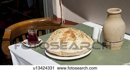 Stock Image - Turkish bread with a glass of drink on a table, Old City, Istanbul, Turkey. Fotosearch