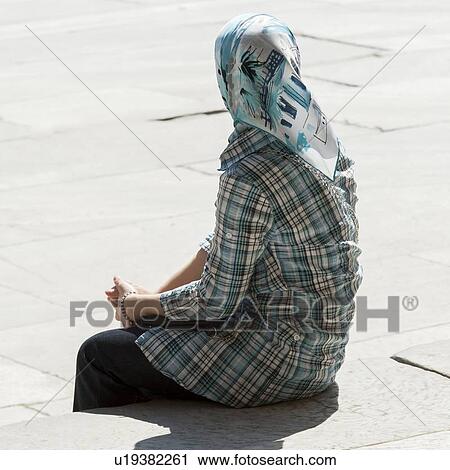 Stock Image - Woman sitting on the steps at Blue Mosque, Istanbul, Turkey. Fotosearch