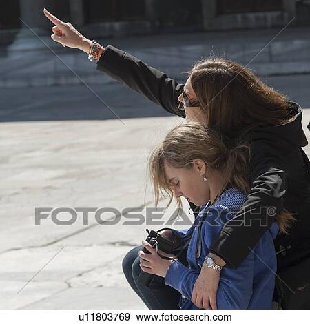 Stock Photo - Woman sitting with her daughter and pointing, Blue Mosque, Istanbul, Turkey. Fotosearch