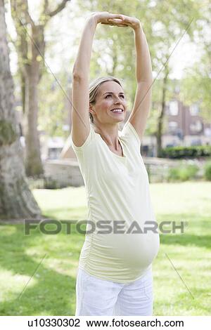 Stock Image - Pregnant woman stretching. Fotosearch