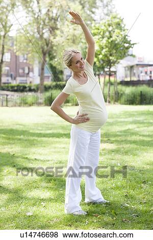 Pregnant woman stretching View Large Photo Image Stock Photo - Pregnant woman stretching. Fotosearch