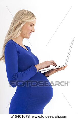 Pregnant woman using a laptop View Large Photo Image Stock Photo - Pregnant woman using a laptop. Fotosearch