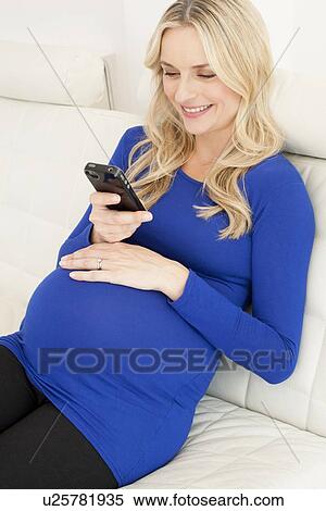 Pregnant woman using a mobile phone View Large Photo Image Stock Photography - Pregnant woman using a mobile phone. Fotosearch
