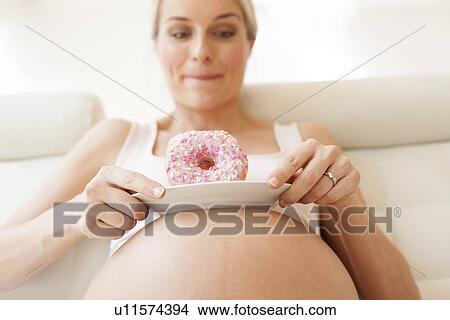 Pregnant woman with doughnuts View Large Photo Image Picture - Pregnant woman with doughnuts. Fotosearch