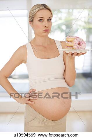 Pregnant woman with doughnuts View Large Photo Image Stock Photo - Pregnant woman with doughnuts. Fotosearch