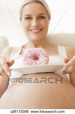 Pregnant woman with doughnuts View Large Photo Image Stock Photograph - Pregnant woman with doughnuts. Fotosearch