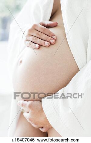 Stock Photograph - Pregnant woman's abdomen. Fotosearch
