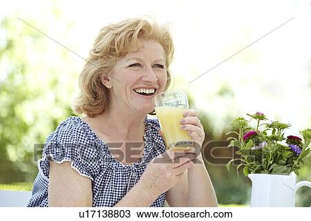 Stock Image - Woman drinking fruit juice. Fotosearch