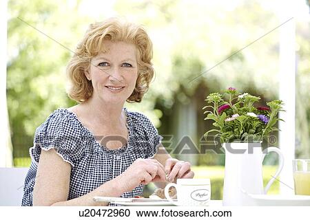 Stock Image - Woman eating breakfast. Fotosearch