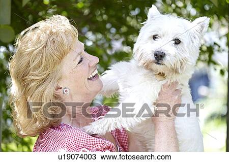 Stock Image - Woman with pet dog. Fotosearch