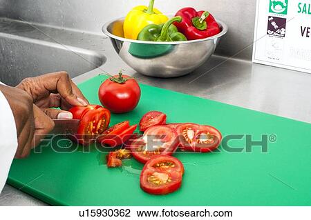 Stock Image - Cutting tomatoes. Fotosearch