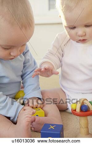 Babies playing with toys together View Large Photo Image Stock Photograph - Babies playing with toys together. Fotosearch