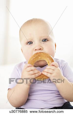 Baby girl eating bagel View Large Photo Image Stock Photography - Baby girl eating bagel. Fotosearch