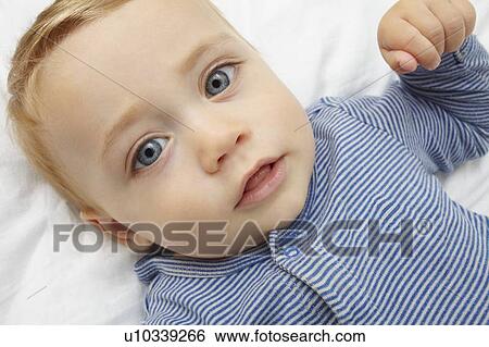 Stock Photograph - Baby girl laying on crib. Fotosearch