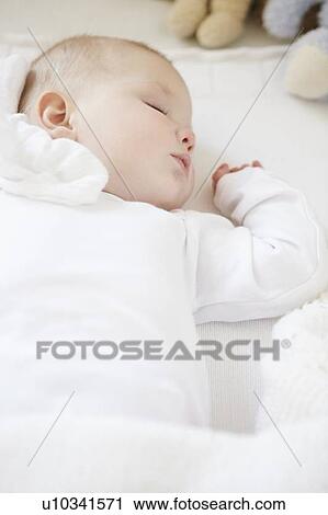 Stock Image - Baby girl sleeping in crib. Fotosearch