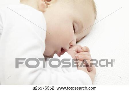 Stock Image - Baby girl sleeping in crib. Fotosearch
