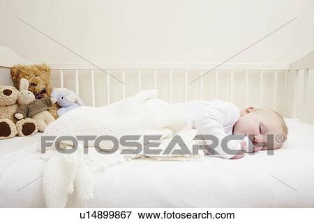 Stock Photo - Baby girl sleeping in crib. Fotosearch