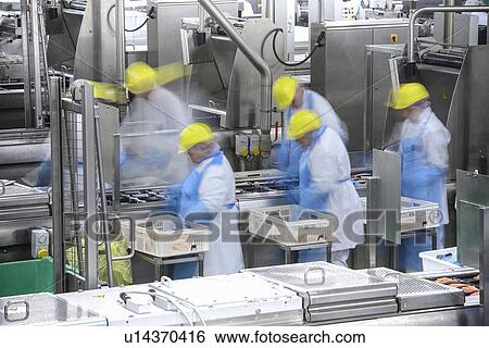 Stock Photograph - Blurred view of workers in factory. Fotosearch