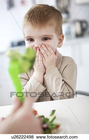 Boy gasping at vegetable at table View Large Photo Image Stock Photo - Boy gasping at vegetable at table. Fotosearch