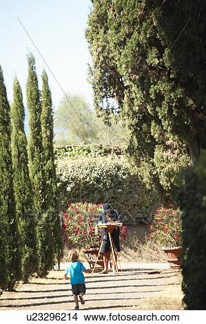 Picture - Boy running to father in garden. Fotosearch