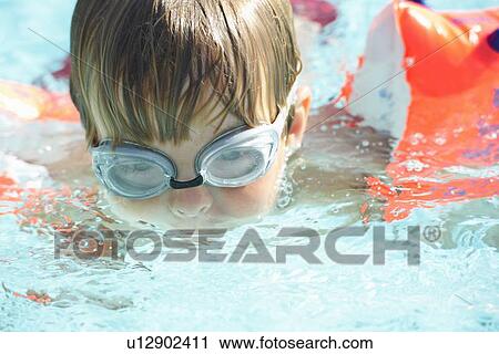 Boy wearing goggles in swimming pool View Large Photo Image Stock Image - Boy wearing goggles in swimming pool. Fotosearch
