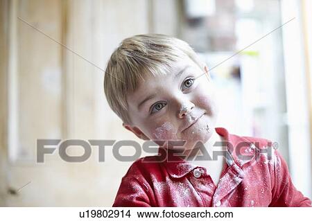 Picture - Boys face covered in flour in kitchen. Fotosearch