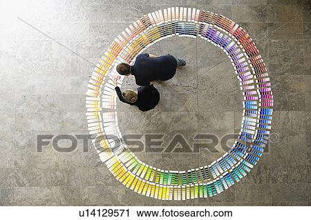 Stock Image - Business people examining paint swatches. Fotosearch