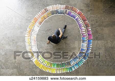 Stock Image - Businessman examining paint swatches. Fotosearch