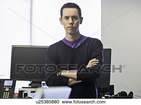Stock Image - Businessman standing in office. Fotosearch