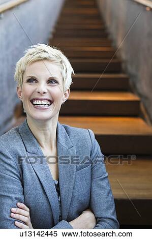 Stock Photography - Businesswoman laughing on stairs. Fotosearch