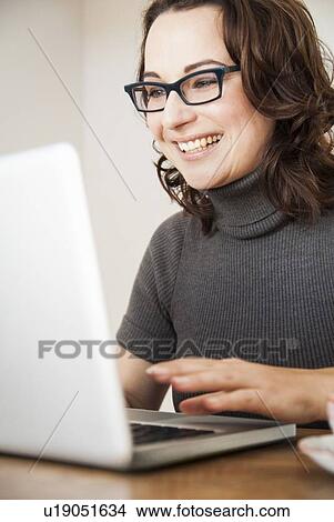 Businesswoman using laptop at desk View Large Photo Image Picture - Businesswoman using laptop at desk. Fotosearch