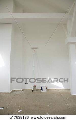 Stock Photograph - Cans of paint and brush in empty house. Fotosearch