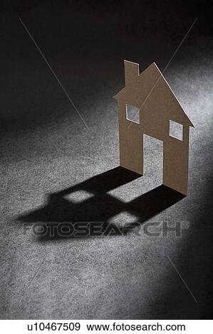 Cardboard house shape casting shadow View Large Photo Image Stock Photo - Cardboard house shape casting shadow. Fotosearch