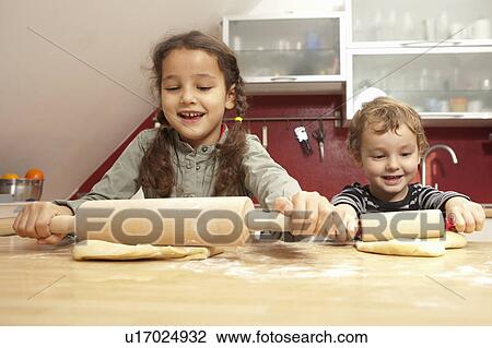 Stock Image - Children baking together in kitchen. Fotosearch