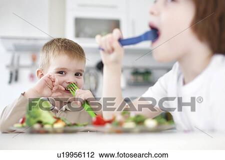 Children eating together at table View Large Photo Image Stock Image - Children eating together at table. Fotosearch