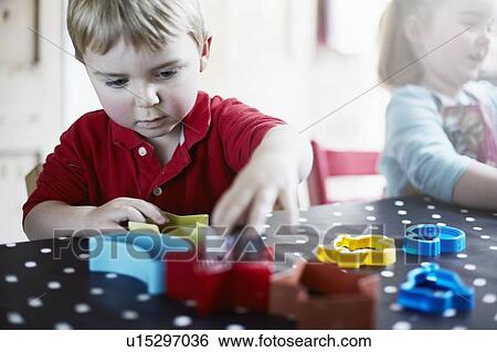 Children playing with shapes on table View Large Photo Image Stock Photograph - Children playing with shapes on table. Fotosearch