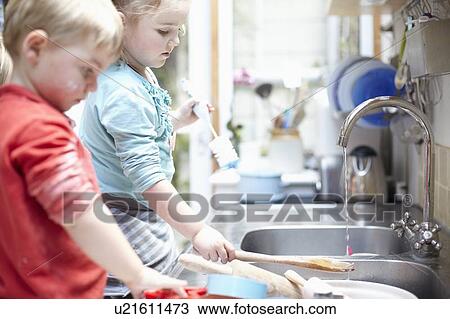 Children washing dishes together View Large Photo Image Stock Image - Children washing dishes together. Fotosearch