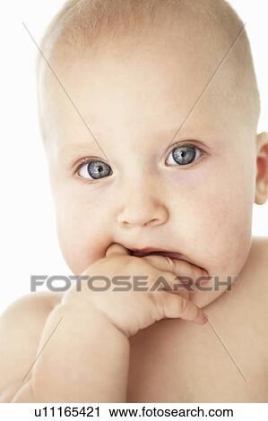 Stock Image - Close up of baby girls curious face. Fotosearch