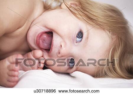Stock Photograph - Close up of baby girls smiling face. Fotosearch