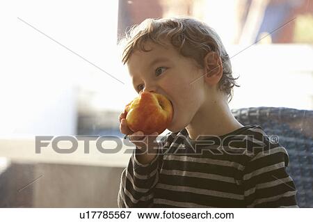 Stock Photo - Close up of boy eating apple. Fotosearch