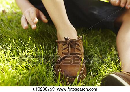 Close up of boys shoelaces in grass View Large Photo Image Stock Photo - Close up of boys shoelaces in grass. Fotosearch