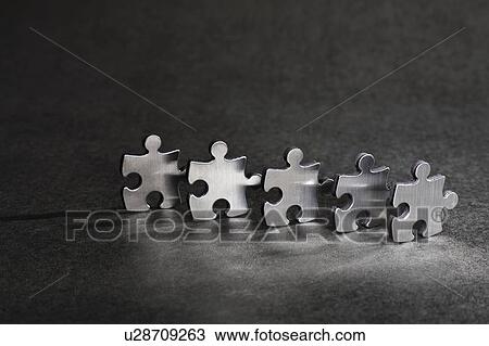 Stock Image - Close up of metal jigsaw pieces. Fotosearch