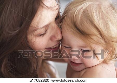 Stock Image - Close up of mother holding daughter. Fotosearch