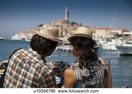 Couple looking at digital photos View Large Photo Image Stock Photograph - Couple looking at digital photos. Fotosearch