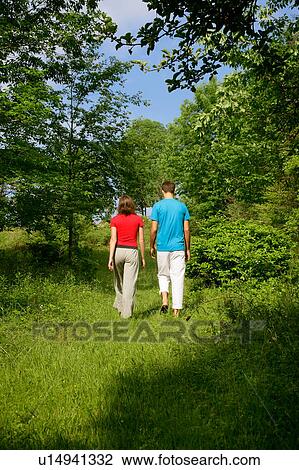 Stock Image - Couple walking in meadow. Fotosearch