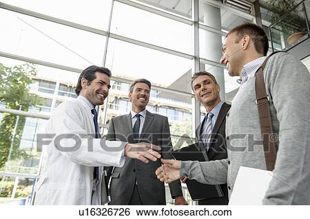 Stock Photograph - Doctor and businessman shaking hands. Fotosearch